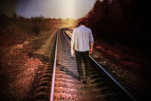 Defeated man on railroad tracks